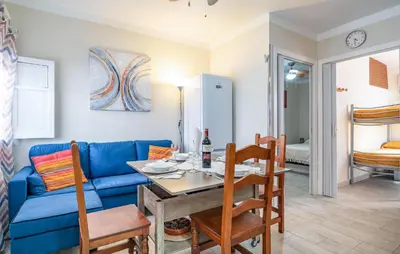 a living room with a blue couch and a table at Nice Apartment In Chipiona With Wifi in Chipiona