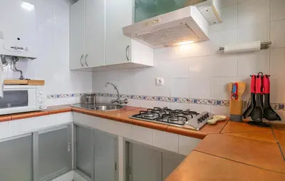 a kitchen with white cabinets and a stove top oven at Nice Apartment In Chipiona With Wifi in Chipiona