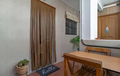 a room with a table and a wooden door at Nice Apartment In Chipiona With Wifi in Chipiona