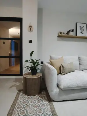 a living room with a couch and a potted plant at Luxe Apartamento Duque de Alta in Arcos de la Frontera