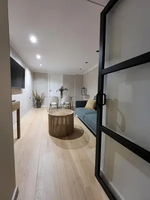a living room with a blue couch and a table at Luxe Apartamento Duque de Alta in Arcos de la Frontera