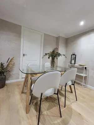 a dining room with a glass table and white chairs at Luxe Apartamento Duque de Alta in Arcos de la Frontera