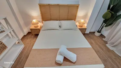 a bedroom with a white bed with two lamps at MANZANILLA CENTRO PLAYA in Sanlúcar de Barrameda