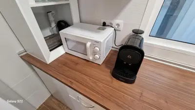 a microwave and a wine bottle on a counter at MANZANILLA CENTRO PLAYA in Sanlúcar de Barrameda