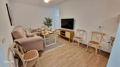 a living room with a couch and a table with chairs at MANZANILLA CENTRO PLAYA in Sanlúcar de Barrameda