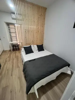 a bedroom with a large white bed with black sheets at Apartamento catedral in Jerez de la Frontera