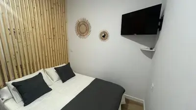 a bedroom with a bed and a flat screen tv at Apartamento catedral in Jerez de la Frontera