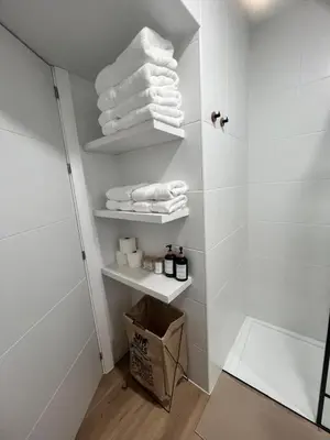 a bathroom with white towels on shelves in a shower at Apartamento catedral in Jerez de la Frontera