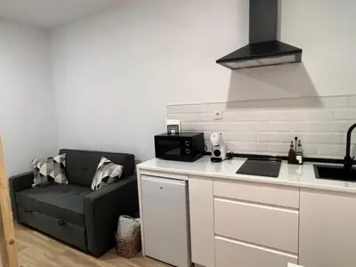 a kitchen with a couch next to a kitchen counter at Apartamento catedral in Jerez de la Frontera