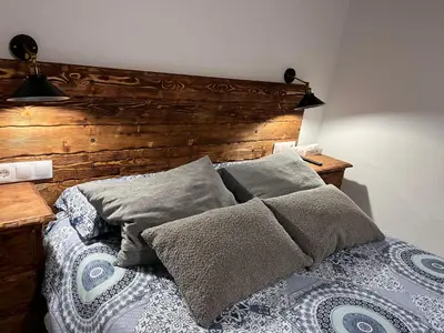 a bedroom with a wooden headboard and a bed with pillows at El Patio de María in Bornos