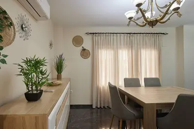 a dining room with a table and chairs and a chandelier at Gades Zuloaga Ha in Cádiz