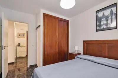 a bedroom with a bed and a wooden door at Gades Zuloaga Ha in Cádiz