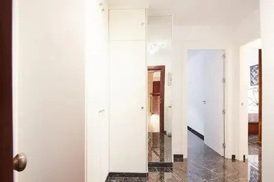 a hallway with white walls and a mirror at Gades Zuloaga Ha in Cádiz