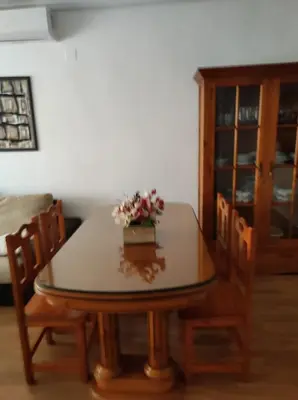 a dining room table with two chairs and a vase of flowers on it at EA bahía sur in San Fernando