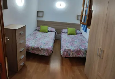 a room with two beds and a dresser in it at EA bahía sur in San Fernando