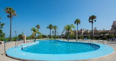 a large swimming pool with palm trees in a resort at EA bahía sur in San Fernando