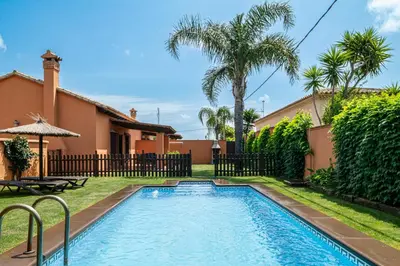 a swimming pool in the yard of a house at Villa Marta Clara in Conil de la Frontera