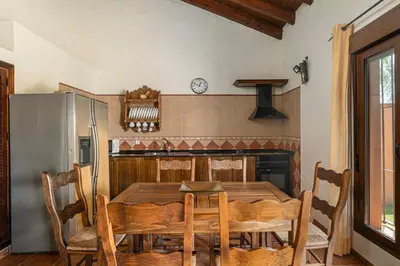 a dining room with a table and a refrigerator at Villa Marta Clara in Conil de la Frontera