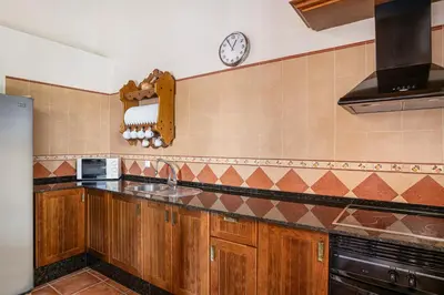 a kitchen with a sink and a clock on the wall at Villa Marta Clara in Conil de la Frontera