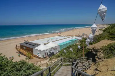 a building on a beach next to the ocean at Apartamento en Chiclana de la Frontera in Chiclana de la Frontera