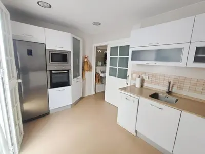 a kitchen with white cabinets and a stainless steel refrigerator at Apartamento en Chiclana de la Frontera in Chiclana de la Frontera