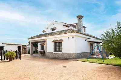 a white house with a playground in front of it at Casa Cala Puntalejo in Conil de la Frontera