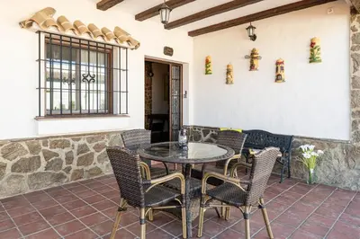 a patio with a glass table and chairs at Casa Cala Puntalejo in Conil de la Frontera