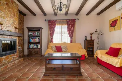 a living room with two beds and a fireplace at Casa Cala Puntalejo in Conil de la Frontera
