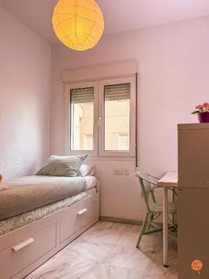 a bedroom with a bed and a desk and a window at El Pelícano Parking free Grupo Ac Gestion in Cádiz
