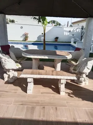 a table and chairs with a tree in a pool at Villa completa con piscina en Arcos de la frontera in Arcos de la Frontera
