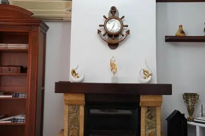 a clock on a wall next to a fireplace at Villa completa con piscina en Arcos de la frontera in Arcos de la Frontera