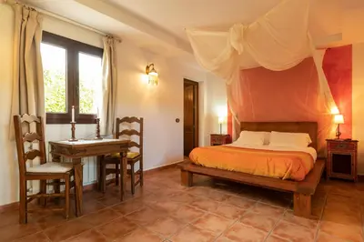 a bedroom with a bed and a table and a desk at Paraiso Perdido in Conil de la Frontera