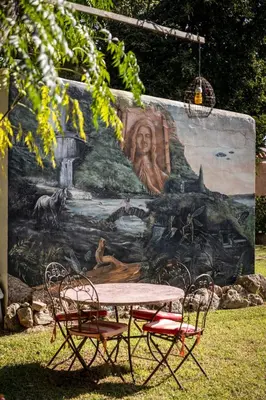 a table and chairs in front of a mural at Paraiso Perdido in Conil de la Frontera