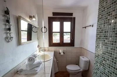 a bathroom with a sink and a toilet and a window at Paraiso Perdido in Conil de la Frontera