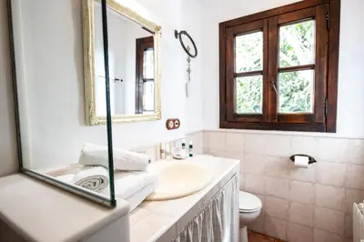a bathroom with a sink and a mirror and a toilet at Paraiso Perdido in Conil de la Frontera