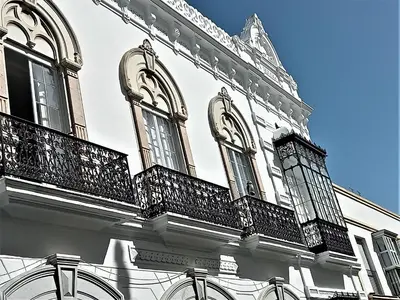 a white building with balconies on the side of it at El Anfitrión Palacio Argüeso 12 in Sanlúcar de Barrameda