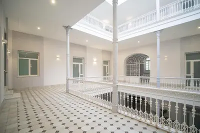 a large room with white columns and a tiled floor at El Anfitrión Palacio Argüeso 12 in Sanlúcar de Barrameda