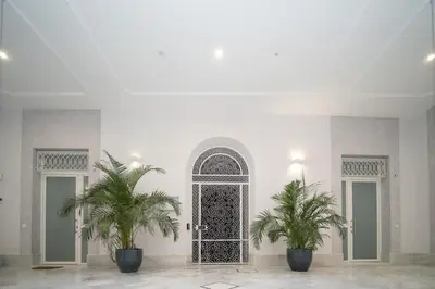 a room with two palm trees in front of a door at El Anfitrión Palacio Argüeso 12 in Sanlúcar de Barrameda