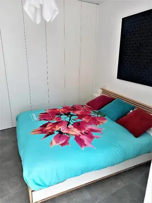 a bedroom with a bed with a flower on it at El Anfitrión Palacio Argüeso 12 in Sanlúcar de Barrameda