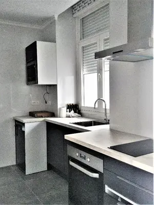 a kitchen with white cabinets and a sink and a window at El Anfitrión Palacio Argüeso 12 in Sanlúcar de Barrameda