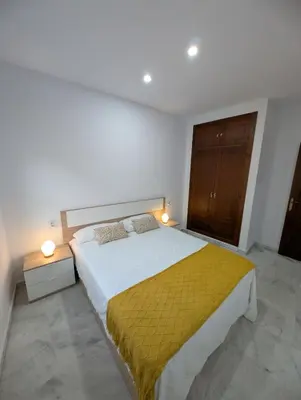 a bedroom with a large bed with a yellow blanket at Casa Brake in Chiclana de la Frontera