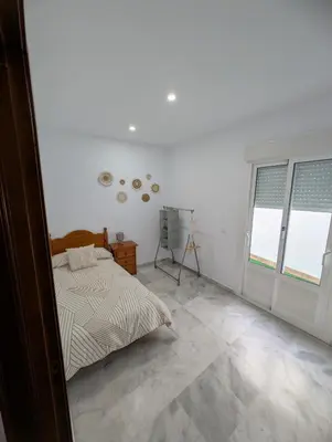 a bedroom with a bed and two windows at Casa Brake in Chiclana de la Frontera