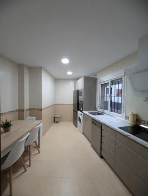 a large kitchen with a table and a counter top at Casa Brake in Chiclana de la Frontera