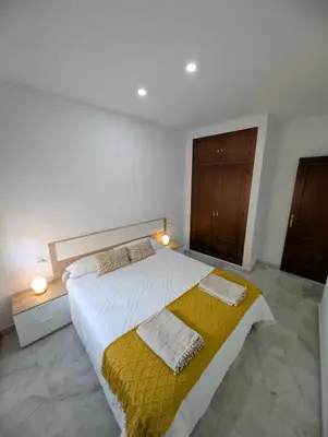 a bedroom with a large bed with a yellow blanket at Casa Brake in Chiclana de la Frontera
