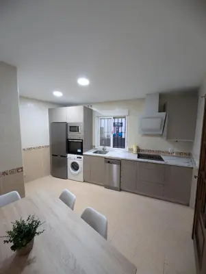 a large kitchen with a table in a room at Casa Brake in Chiclana de la Frontera