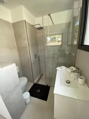 a white bathroom with a shower and a toilet at Mas del Cullou, moderne Villa in Andalusien, in der Nähe vom Meer in Cádiz