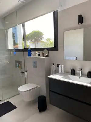 a bathroom with a sink and a toilet and a mirror at Mas del Cullou, moderne Villa in Andalusien, in der Nähe vom Meer in Cádiz