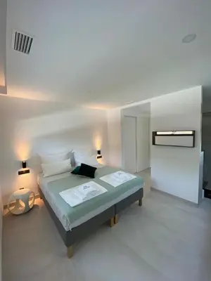 a bedroom with a bed with two lamps and a tv at Mas del Cullou, moderne Villa in Andalusien, in der Nähe vom Meer in Cádiz