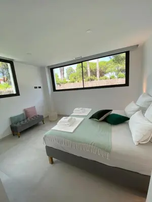a bedroom with a large bed and two windows at Mas del Cullou, moderne Villa in Andalusien, in der Nähe vom Meer in Cádiz