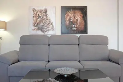 a living room with two paintings of lions and a couch at Casa Borpa - Solo Familias in Conil de la Frontera